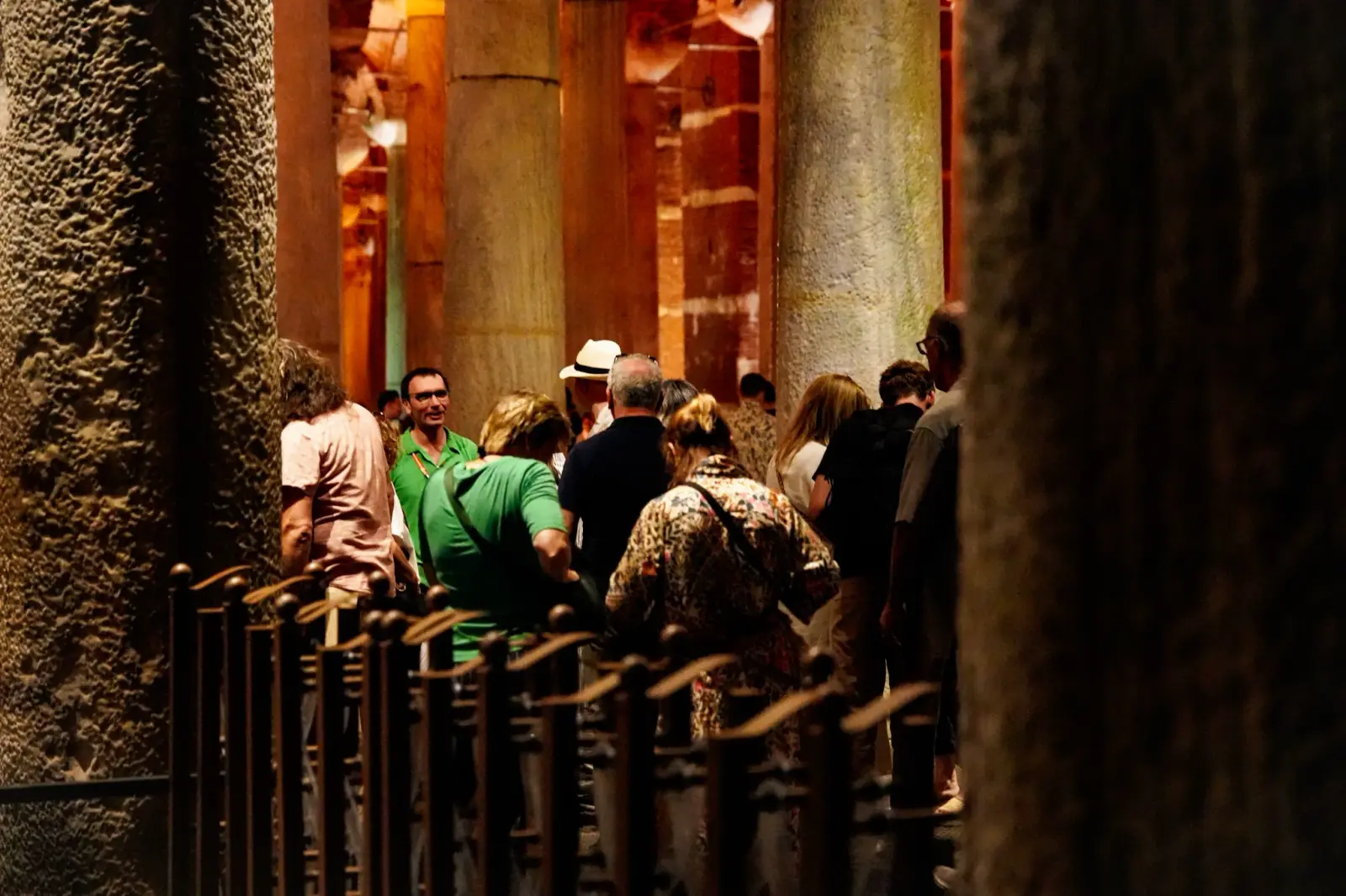 Visitors on the raised walkway between the columns, a low rail running along the edge of the water.