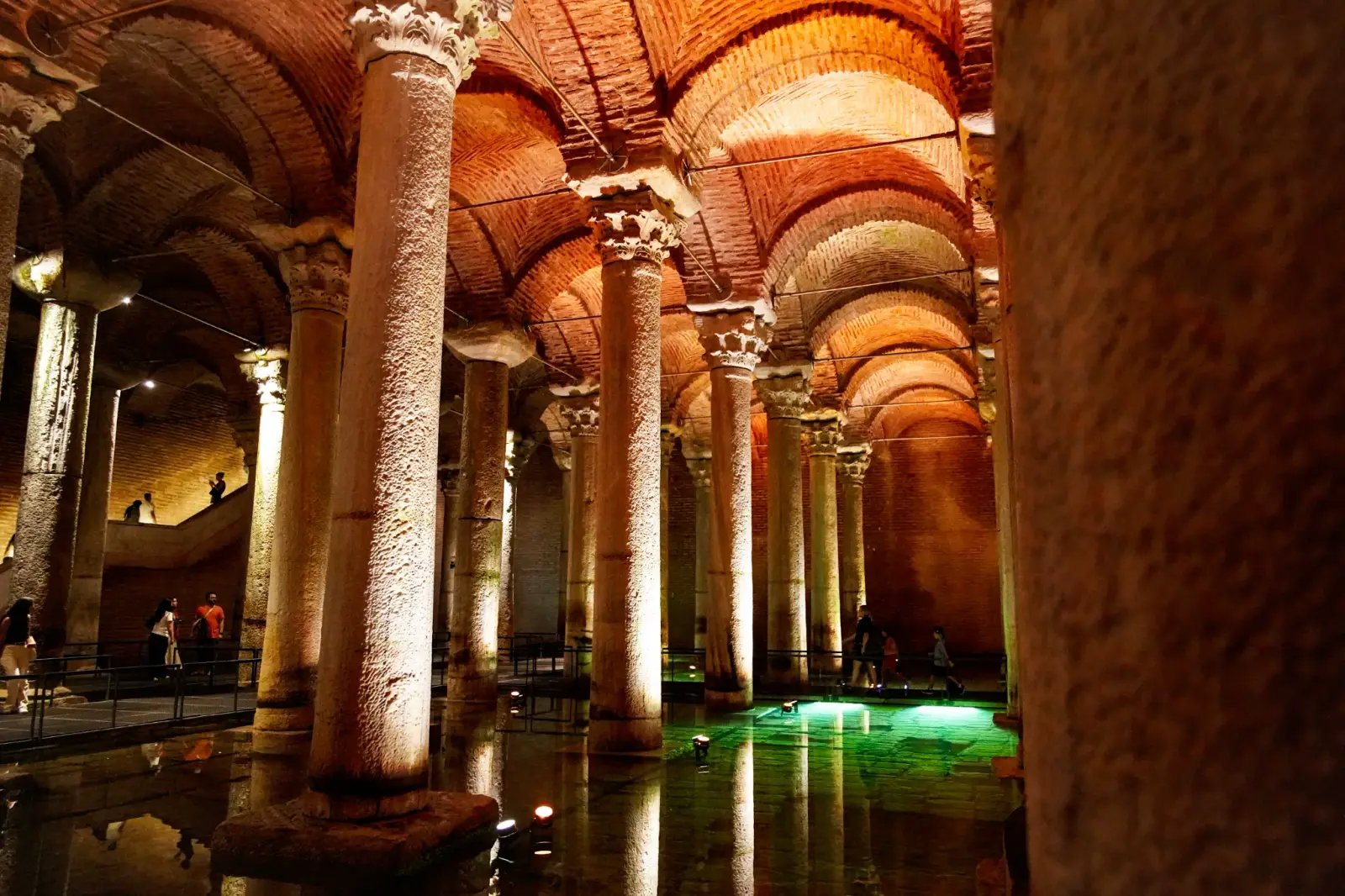 A row of shafts receding towards the stair, Corinthian and plain capitals in the same frame.