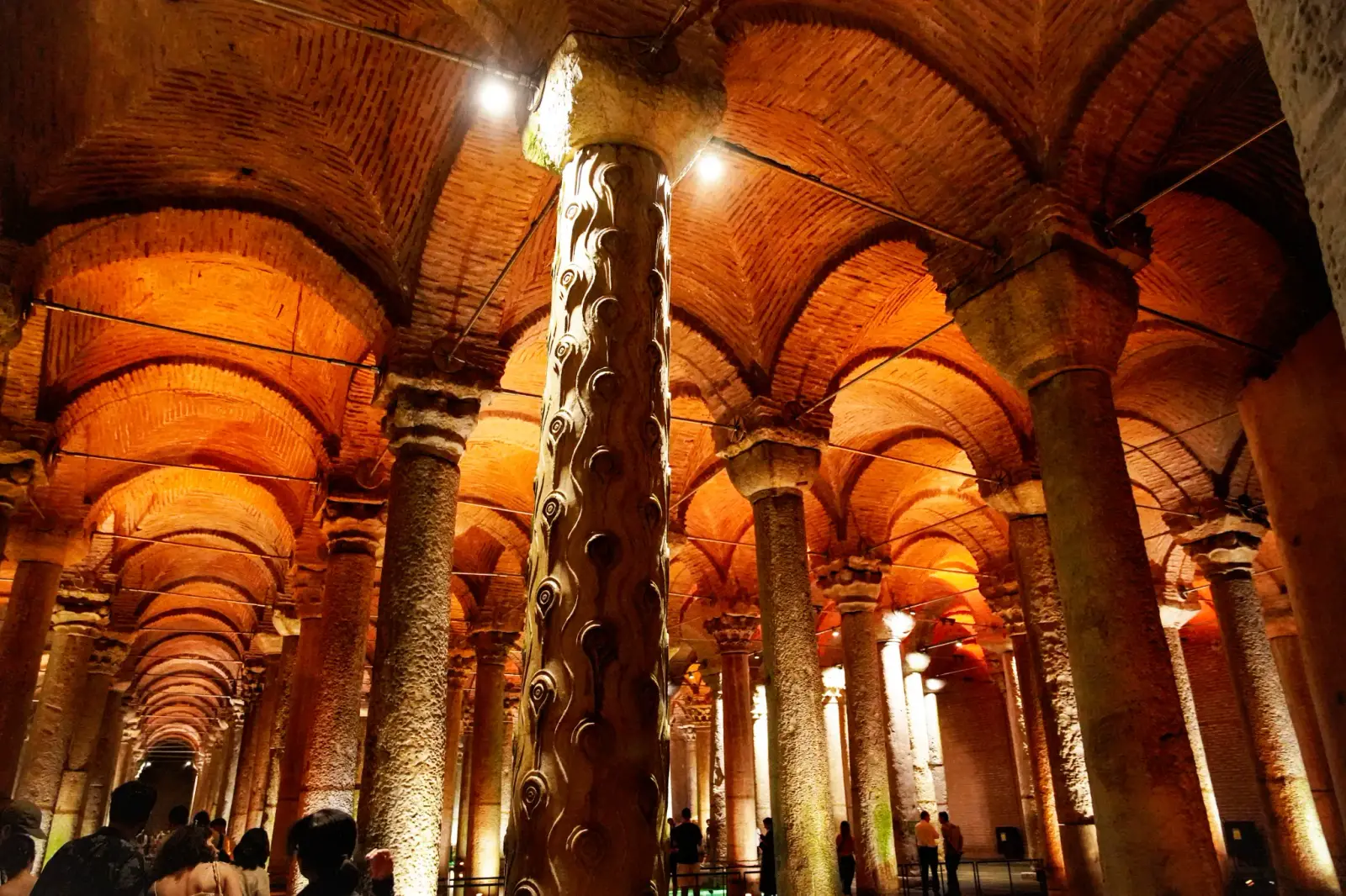 The Weeping Column, its shaft carved with teardrop and eye motifs, wet under the lit brick vaults.